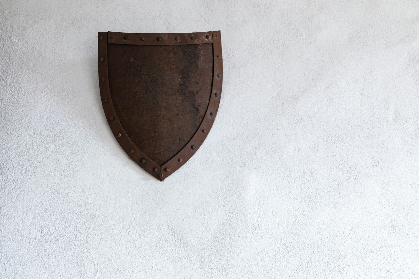 Escudo de metal na parede, representando guardrails de segurança na AWS