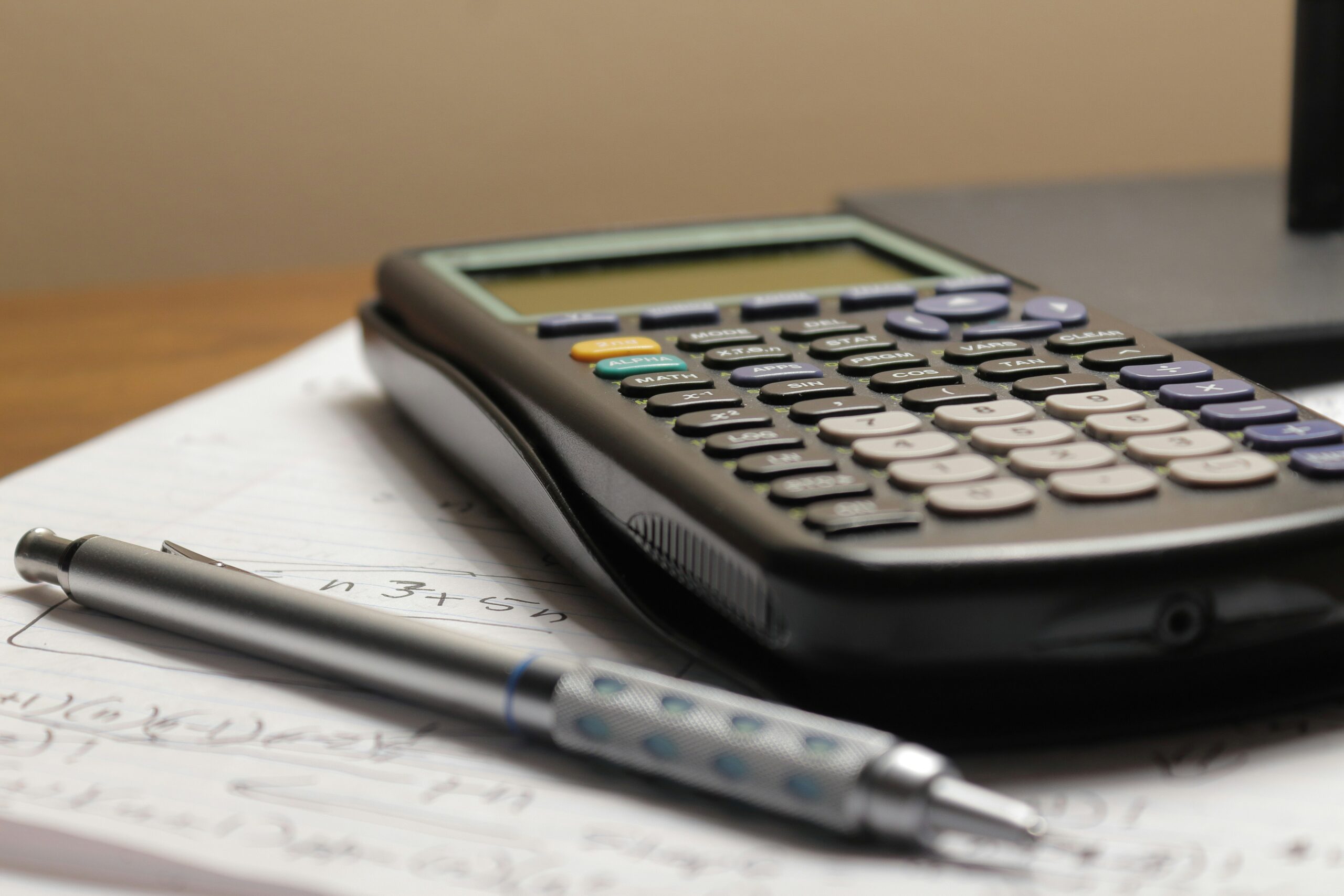 Calculadora e caneta sobre papel representando o cálculo de economia entre Savings Plans e Reserved Instances
