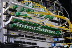 Cabos de fibra óptica conectados a um switch de rede representando uma conexão AWS Direct Connect