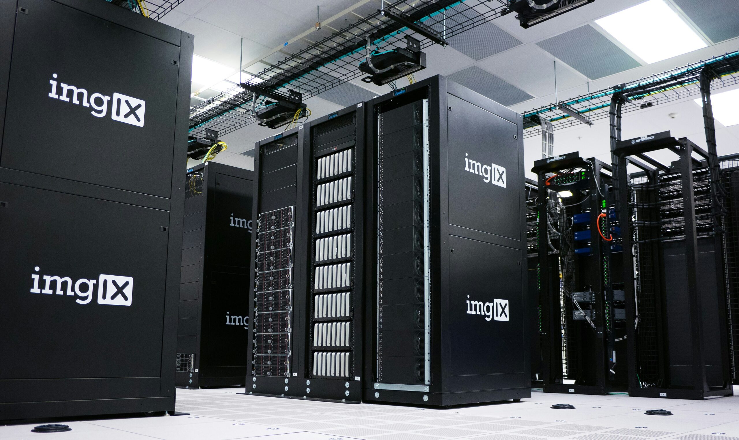 Fileiras de racks de servidores em datacenter representando uma arquitetura de conectividade redundante